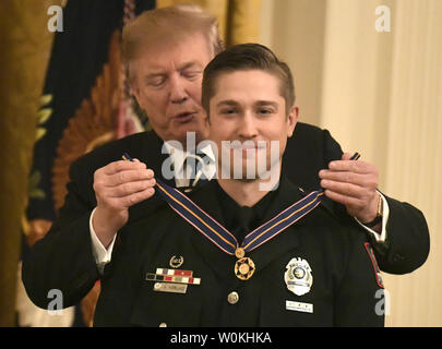 Präsident Donald Trump (L) stellt eine Medaille von Valor zu Ohio State University Officer Alan Horujko, im Osten Zimmer im Weißen Haus, Washington, DC, 22. Mai 2019. Horujko wurde für seine Intervention beim automatischen und Messer angriff auf Studenten und Zivilisten auf der Columbus, Ohio Campus im Jahr 2016 geehrt. Foto von Mike Theiler/UPI Stockfoto