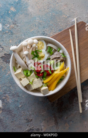 Nudeln mit Pilzen und Gemüse in der Schüssel. Paprika, gelb Paprika, Tofu, Zwiebeln, gekochtem Rindfleisch und Chinesische Pilze Stockfoto