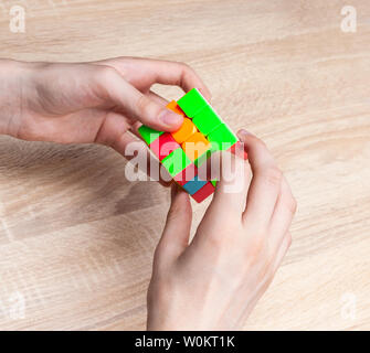 Junge holding Rubik's Cube und spielen mit ihm. Rubik's Cube in den Händen des Kindes, Nahaufnahme. Stockfoto