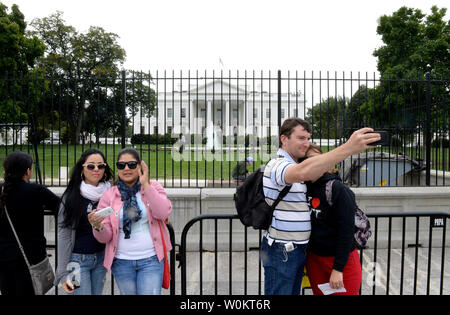 Touristen nehmen Sie Fotos von sich selbst vor einem zweiten Sicherheitszaun im Weißen Haus in Washington, DC am 24. September 2014. Die temporäre zweite Zaun wurde installiert, wie der Geheimdienst seine Untersuchung des Zauns - springen Ereignis des 19. September, in denen eine Armee Veteran es vor die Tür des Weißen Hauses gemacht konkurriert. UPI/Pat Benic Stockfoto