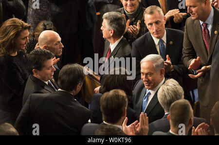 Der israelische Premierminister Benjamin Netanjahu ankommt und grüßt Demokraten (unten links) und Republikaner (oben rechts) vor der Adressierung einer gemeinsamen Sitzung des Kongresses der Vereinigten Staaten auf dem Capitol Hill in Washington DC am 3. März 2015. In einer umstrittenen Rede, Netanyahu argumentierte gegen ein Abkommen mit dem Iran auf ihre Atomwaffen wie nukleare Verhandlungen mit der Regierung Obama und Iran in Genf fort. Foto von Pat Benic/UPI Stockfoto