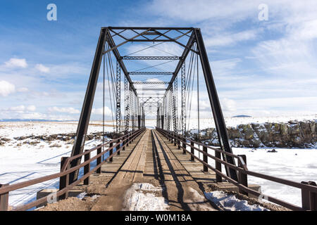 San Juan County, Colorado - Februar 21, 2019: Ein 1892 schmiedeeiserne Brücke über den Rio Grande im Winter mit Schnee, Eis, blauer Himmel, Wolken. Gebaut b Stockfoto