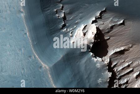 Dieses Bild hat am 24. November 2015 erworben, die von der High Resolution Imaging Science Experiment (HiRISE-Kamera an Bord der NASA-Mars Reconnaissance Orbiter, zeigt die westliche Seite eines länglichen Grube Depression in der östlichen Region Noctis Labyrinthus des Mars. Entlang der oberen Wand des Pit ist ein hellen Farben geschichtet. UPI Stockfoto