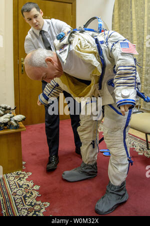 Expedition 47 NASA-Astronaut Jeff Williams zieht seine russischen Sokol Anzug mit etwas Hilfe von NASA-Crew Chirurg und Star City Kampf Arzt James Pattarini, am letzten Tag der Sojus Qualifikation Prüfungen mit Russischen Kosmonauten Oleg Skripochka, und Alexej Ovchinin von Roskosmos, am 25. Februar 2016, an der Gagarin Cosmonaut Training Centre (GCTC) in Star City, Russland. NASA Foto von Bill Ingalls/UPI Stockfoto