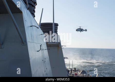 Einem russischen Kamov Ka-27 Helix eng surveils die USS Donald Cook (DDG75) am 12. April 2016, bei Manövern in internationalen Gewässern in der Ostsee. Donald Cook, eine der Arleigh-Burke-Klasse geführte-missile Destroyer, vorwärts zu Rota, Spanien bereitgestellt werden, ist die Durchführung einer Routinepatrouille in den USA 6 Flotte Bereich der Maßnahmen zur Unterstützung der US-amerikanischen nationalen Sicherheitsinteressen in Europa. Foto: US Navy/UPI Stockfoto