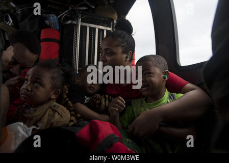 Eine Familie von Evakuierten warten auf den Rest ihrer Familie Mitglieder an Bord eines HH-60G Pave Hawk, zu den 41 Rescue Squadron zugeteilt, der am 30. August 2017, über einen Wohnsitz in der Houston, Texas. Die 347 Rettung Gruppe von Moody Air Force Base, Ga reagierte mit seiner Rettung von Flugzeugen und Personal zur Unterstützung der FEMA nach Hurrikan Harvey Überflutungen und Zerstörungen in den Teilen von Texas gebracht. Foto von Tech. Sgt. Zachary Wolf/U.S. Luftwaffe/UPI Stockfoto