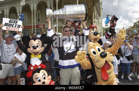 Von Fans umgeben und von Disney Figuren begleitet, Tampa Bay Lightning Team Captain Dave Andreychuk Hebezeuge den Stanley Cup hoch über den Kopf nach einer Siegesparade der Main Street USA heute im Magic Kingdom in Lake Buena Vista, FL am 12. Juni. 2004. Andreychuk, 40, wurde in den Walt Disney World Theme Park geehrt erste NHL Meisterschaft seiner Mannschaft zu feiern. (UPI Foto/Gene Duncan) Stockfoto