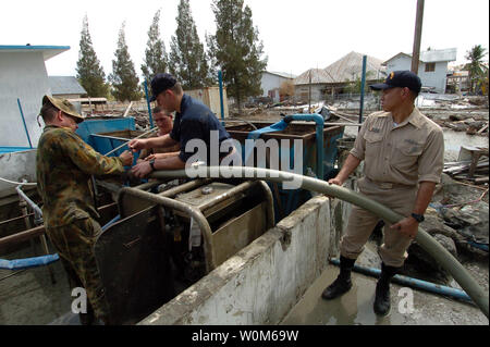 Navy und Marine Corps Personalarbeit mit einer Royal Australian Ingenieur zu einer Wasserpumpe System in der Innenstadt und der medizinische Komplex in Banda Aceh, Sumatra, Indonesien Reparatur, Jan. 9, 2005. Hubschrauber Carrier Air Wing Zwei (CVW-2) und Matrosen von Abraham Lincoln zugeordnet sind, unterstützt den Betrieb von Unified Hilfe, humanitäre Hilfe Aufwand im Zuge der Tsunami, der Südostasien heimgesucht. (UPI Foto/US Navy/Alan D. Monyelle) Stockfoto