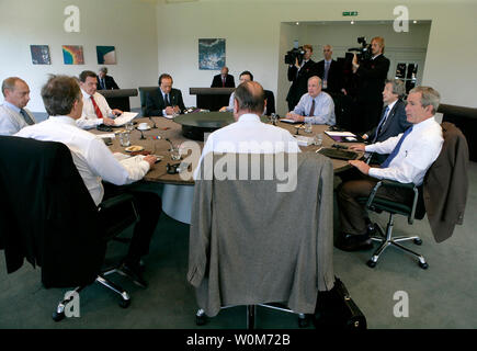 Präsident George W. Bush sitzt mit Staats- und Regierungschefs der G8 Donnerstag, 7. Juli 2005, während ihrer ersten Sitzung in Gleneagles Hotel in Auchterarder, Schottland. Im Uhrzeigersinn, vom Präsidenten, sind: Der französische Präsident Jacques Chirac und Premierminister Tony Blair von England; der russische Präsident Wladimir Putin und der deutsche Bundeskanzler Gerhard Schröder; der italienische Ministerpräsident Silvio Berlusconi, der Präsident der Europäischen Kommission, Jose Manuel Barroso, der kanadische Premierminister Paul Martin, und der japanische Ministerpräsident Junichiro Koizumi. (UPI Foto/Eric Draper/Weiße Haus) Stockfoto