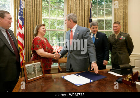 Präsident George W. Bush schüttelt die Hand von Janet Norwood nach der Unterzeichnung in Gesetz H.R. 1001, die Benennung der Sergeant Byron W. Borwood Postgebäude, die Benennung der US Postal Service facility in Pflugerville, Texas, zu Ehren der 25-jährigen Marine, der im Kampf gestorben, im Weißen Haus am 21. Juli 2001. Bei Frau Norwood und der Präsident für die Unterzeichnung, von links: Bill Norwood, Ehemann und Vater; Kongressabgeordnete Michael McCaul, R - Texas, und Erste Lt T. Ryan Sparks, 3.BATAILLON, 1 Marines. (UPI Foto/Eric Draper/Weiße Haus) Stockfoto