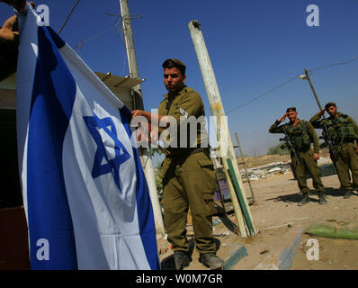 Offiziere in der Armee begrüssen als israelische Soldaten aus der Golani Brigade unter der Flagge, wie sie sich vorbereiten, 11. September 2005 von der Yareach Außenposten im südlichen Gazastreifen zurückzuziehen. Israel wird voraussichtlich die letzten ihrer Truppen aus dem Gazastreifen innerhalb von Stunden, einen historischen Ende nach 38 Jahren der Besatzung der palästinensischen Gebiet zurückzuziehen. (UPI Foto/David Silverman/Pool) Stockfoto