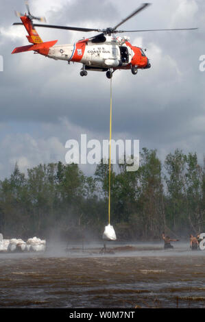 Ein Coast Guard HH-60 Jayhawk Helikopter Crew von Kodiak, Alaska, aus der Air Station Houston, fällt einem sandsack ein beschädigter Deiche in New Orleans an Sept. 29, 2005 zu reparieren. Die Küstenwache gesunken 18.000 Pfund Sand, während der Arbeit mit der National Guard der überschritten Deiche zu rekonstruieren. (UPI Foto/Christopher Evanson/USCG) Stockfoto