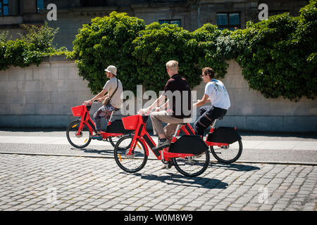 Berlin, Deutschland - Juni, 2019: Drei junge Männer reiten ebikes oder. e-bikes Fahrrad Sharing Service springen von UBER in Berlin Stockfoto