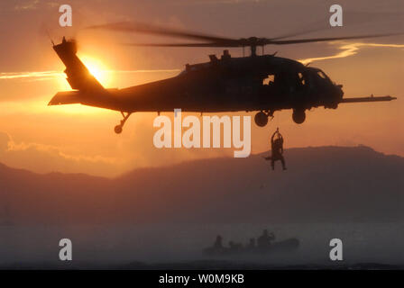 Flieger aus dem 18 Wing an Kadena Air Base, Japan, sind an Bord eines 33 Rescue Squadron HH-60 Hawk Hubschrauber in einer Übung ebnen brachte hielt weg von der Küste von Okinawa vom 29. August 2006. Die Flieger herausgefordert, ihre Retter mit mehreren simulierten Verletzungen einschließlich psychologische Bedrängnis während der Übung. Die 18 Flügel und die 353 Special Operations Group die Masse Unfallversicherung Übung die Rettung und Notfallversorgung Fähigkeiten von Kadena Air Base zu testen. (UPI Foto/Jeremy McGuffin/USAF) Stockfoto