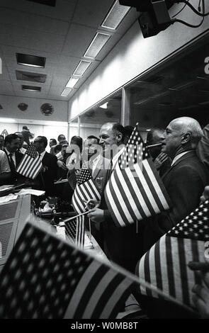 Bemannte Raumfahrzeuge Center (MSC) Beamten melden Sie sich mit dem Flight Controller, der in der Mission Operations Control Room (Mocr) im Mission Control Center (MCC), feiern den erfolgreichen Abschluss der Apollo 11 Mondlandung Mission am 20. Juli 1969. Die NASA feiert den 50. Jahrestag der Space Age vom Oktober 4, 1957 Start von Sputnik, den ersten künstlichen Satelliten der Welt, der Sowjetunion. Erkennbar in der Bild, beginnend im Vordergrund, sind Dr. Robert R. Gilruth, MSC Direktor; George M. Niedrig, Manager, Apollo Raumschiff Programm, MSC; Dr. Christopher C. Kra Stockfoto