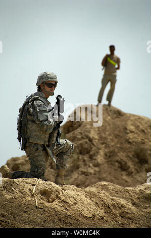 Ein US-Soldat (L) Form Bravo Batterie, 4.Bataillon, 27 Field Artillery Regiment, 2nd Brigade Combat Team, 1. Panzerdivision und Söhne des Irak die Sicherheit während einer tierärztlichen Betrieb in Bagdad, Irak am 11. Mai 2008. Söhne des Irak ist ein Sicherheit Kraft aus Gruppen der lokalen Bewohner, die helfen, die Sicherheit in ihren eigenen Dörfern und Nachbarschaften zu erhalten. (UPI Foto/David J. Marshall/U.S. Armee) Stockfoto