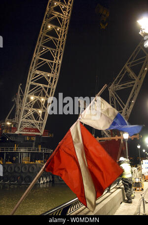 Taucher unten, und Taucher im Wasser Fahnen wehen am Abend Schauer, wie technische Taucher das Wrack der US Airways Flug 1549 für den Ausbau von seinem provisorischen Liegeplatz entlang einer ufermauer in Lower Manhattan am 17. Januar 2009 in New York vorzubereiten. Der Airbus A320 stürzte in den Hudson River am Donnerstag, 31.01.15. (UPI Foto/Edouard H.R. Gluck/Pool) Stockfoto