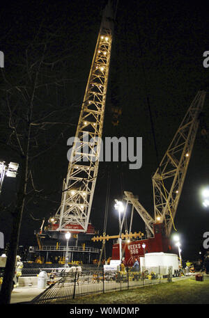 Riesige Kräne Aufstieg in den Abendhimmel über dem Wrack von US Airways Flug 1549 als bergungsgruppe Crews bereiten Sie den Airbus A320 von der provisorischen Liegeplatz entlang einer ufermauer in Lower Manhattan am 17. Januar 2009 in New York zu entfernen. Der Airbus A320 stürzte in den Hudson River am Donnerstag, 31.01.15. (UPI Foto/Edouard H.R. Gluck/Pool) Stockfoto