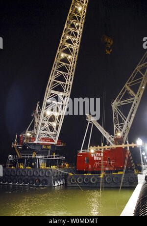 Riesige Kräne Aufstieg in den Abendhimmel über dem Wrack von US Airways Flug 1549 als bergungsgruppe Crews bereiten Sie den Airbus A320 von der provisorischen Liegeplatz entlang einer ufermauer in Lower Manhattan am 17. Januar 2009 in New York zu entfernen. Der Airbus A320 stürzte in den Hudson River am Donnerstag, 31.01.15. (UPI Foto/Edouard H.R. Gluck/Pool) Stockfoto