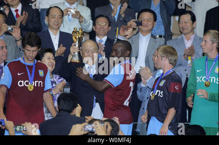 Reverend Sun Myung Moon hält die Peace Cup mit Aston Villa Kapitän Nigel Reo-Coker nach Aston Villa Juventus 4-3 im Elfmeterschießen im La Cartuja Stadion in Sevilla, Spanien, 2. August 2009 besiegt. Das Spiel war 0-0 nach Verordnung gebunden. Reverend Moon's Frau Dr. Hak Ja Han Moon ist auf der linken Seite. UPI/Paco Puentes Stockfoto