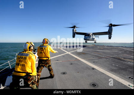 Aviation Boatswains Mate 2. Klasse Dustin Shipman (R), zugeordnet zu den amphibious Transport dock Schiff Pre-Commissioning Steuergerät (PCU) New York LPD (21), leitet eine MV-22 Osprey auf dem Flugdeck am 19. Oktober 2009 zu landen. Die Osprey war das erste Flugzeug, das an Bord des Schiffes, das über 7,5 Tonnen World Trade Center Stahl in Ihrem Bogen zu landen. Die New York geplant ist November 7, 2009 in New York City in Betrieb genommen werden. UPI/Corey Lewis/U.S. Marine. Stockfoto