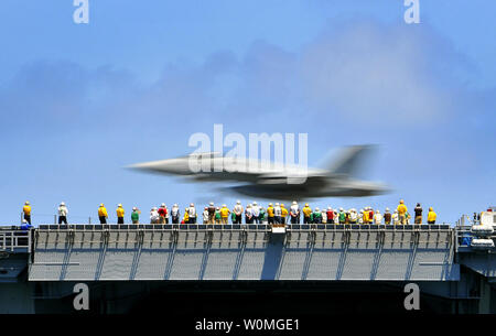 Us-Segler beobachten einen FA/18 E Super Hornet aircraft Land während des Flugbetriebs an Bord der Flugzeugträger USS Carl Vinson (CVN 70) während in den Pazifischen Ozean am 28. März 2010, UPI/Daniel Barker/U.S. Marine Stockfoto