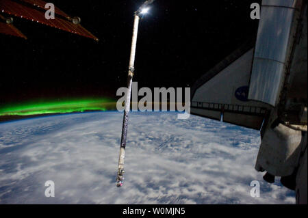 Dieser NASA Image am 14 Juli, 2011 durch die Mitglieder der gemischten Mannschaften der NASA-Mission STS-135 und die Besatzung der Internationalen Raumstation an Bord zeigt dieses Bild von Atlantis und seine Umlaufbahn Boom Sensor System roboterarm Erweiterung backdropped gegen den Horizont der Erde und eine grünliche Phänomen mit Aurora Australis zugeordnet. Eine Solaranlage die Station erscheint oben links. Space Shuttle Atlantis ist an der Internationalen Raumstation auf der Mission STS-135, der letzte Shuttle Mission. UPI/NASA Stockfoto