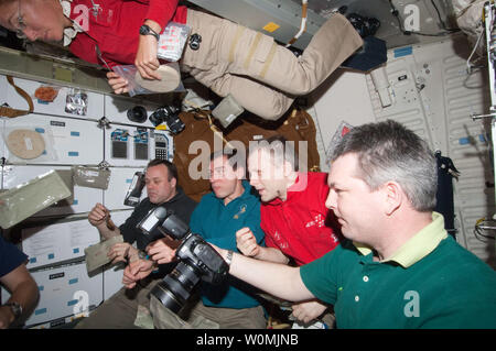 Dieser NASA Image am 14 Juli, 2011 zeigt die Hälfte der Besatzungsmitglieder für die gemeinsame Atlantis - Internationale Raumstation komplex, wie sie sich vorbereiten, zu genießen und "All-American Meal' auf der Shuttle middeck während der Mission STS-135. NASA-Astronaut Sandra Magnus, STS-135 Mission Specialist, schwimmt oben auf dem Rahmen, wie andere Mitglieder der Besatzung werden von der Linken, einschließlich gesehen, NASA-Astronaut Ron Garan, und russischen Kosmonauten Sergej Wolkow, Andrey Borisenko und Alexander. Space Shuttle Atlantis ist an der Internationalen Raumstation auf der Mission STS-135, der letzte Shuttle Mission. UPI/NASA Stockfoto