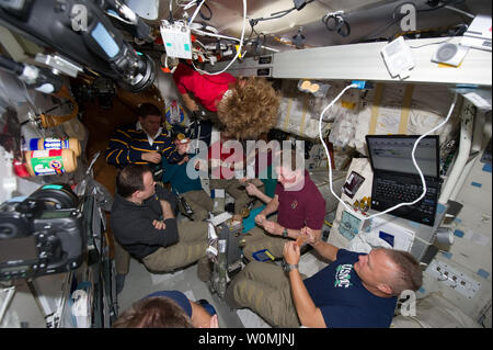 Dieser NASA Image am 14 Juli, 2011 zeigt die sieben Astronauten, sechs von der NASA und einer von der Japan Aerospace Exploration Agency (JAXA), und drei russischen Kosmonauten wie Sie essen, eine spezielle Mahlzeit auf dem Space Shuttle Atlantis' middeck. Eine der letzten Mahlzeiten zwischen Shuttle und station Besatzung geteilt wurde als "All-American Meal." Die STS-135 Crew besteht aus NASA-Astronauten Chris Ferguson, Doug Hurley, Sandy Magnus und Rex Walheim; die Expedition 28 oder Internationale Raumstation Besatzungsmitglieder JAXA Astronauten Satoshi Furukawa, NASA-Astronauten Ron Garan und Mike Fossum, und Russisch Stockfoto