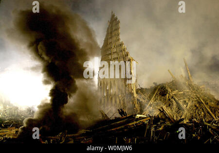 Eine Wolke von Rauch steigt aus einem Kraftstofftank Feuer in einem Gebiet namens "Ground Zero" in New York City als Tonnen Trümmer noch bleiben, einschließlich einer teilweisen stehend an der Wand des World Trade Center, 17. September 2001, eine Woche nach dem verheerenden Angriff durch Terroristen. UPI/Chris Corder Stockfoto