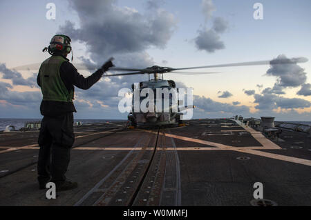 U.S. Navy Aviation Electronics Technician 3. Klasse Marqueze Coleman Signale an ein SH-60R Seahawk Hubschrauber an Bord der Lenkwaffen-zerstörer USS Schwer (DDG107) im Mittelmeer Oktober 5, 2013. Das war schwer auf einem geplanten Einsatz unterstützen Maritime Security Operations und Theater Sicherheit Zusammenarbeit in den USA 6 Flotte Verantwortungsbereich. UPI/D.G. Kenney/DoD Stockfoto