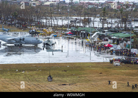 Ein U.S. Navy MH-60S Seahawk Hubschrauber tropfen Hilfsgüter wie das US-Militär bei Hilfsmaßnahmen in der Folge des Taifuns Haiyan, in Edenton, Provinz Leyte, Philippinen, Nov. 14, 2013. Us-Militärs sind die Unterstützung der philippinischen Streitkräfte bei der Bereitstellung humanitärer Hilfe und Katastrophenhilfe in den betroffenen Bereichen in den Philippinen nach der tödlichen Taifun, die 2.357 toten Links. UPI/Ricardo R. Guzman/US Navy Stockfoto