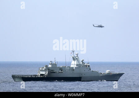 Die Royal Malaysian Navy Korvette KD Terengganu und einem U.S. Navy MH-60R Sea Hawk Hubschrauber von der Blauen Falken der Hubschrauber Maritime Strike Geschwader von der geführten Anti-raketen-Zerstörer USS Pinckney, Durchführung einer koordinierten Luft und Wasser, die Suche nach der vermissten Malaysian Airlines Flug MH370 Jet im Golf von Thailand am 12. März 2014. UPI/Claudia Franco/U.S. Marine Stockfoto