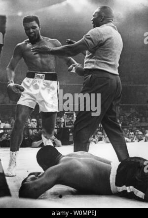 Große boxen Muhammad Ali starb im Alter von 74 Jahren in Phoenix, Arizona am Samstag, 4. Juni 2016. Er ist gezeigt wird durch den Schiedsrichter Joe Walcott zurückgehalten, nachdem er kampfunfähig Sonny Liston in der ersten Runde von ihren Titel kämpfen am 25. Mai 1965 in Lewiston, Maine. Er war als Cassius Clay bekannt vor seinem Namen zu ändern. UPI Stockfoto