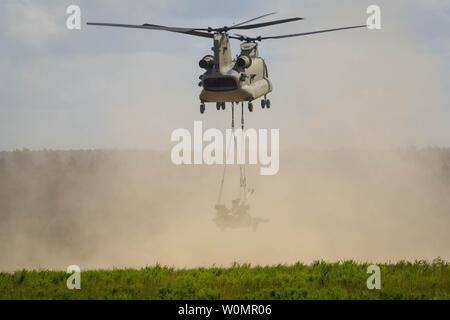 Eine CH-47 Chinook mit der 82Nd Combat Aviation Brigade, steigt nach Airborne Artilleristen in den zweiten Bataillon zugeordnet, 319 Airborne Field Artillery Regiment, Sling laden Sie ein M777A2, während eines zwei gun Raid und Übung auf Fort Bragg, N.C., Aug 10, 2016. Foto von Adan Cazarez/U.S. Armee/UPI Stockfoto