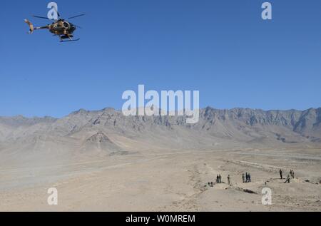 Einen afghanischen Luftwaffe MD-530 Hubschrauber fliegt über Afghanische Nationale Verteidigungs- und Sicherheitskräfte Mitglieder während einer Air-to-Ground Integration Übung in der Provinz Kabul, Afghanistan, 27. Dezember 2016. Die Intergration von Luft-/Boden- Ausbildung usied Antenne Brände und Close Air Support Funktionen für ANDSF Operationen weiter zu entwickeln. NATO-Foto von Kay M. Nissen/UPI Stockfoto