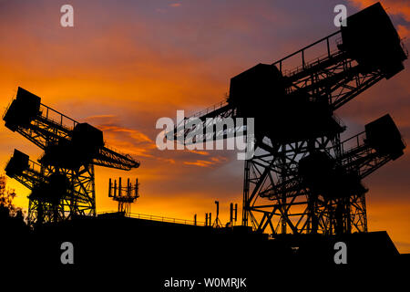 Silhouette, der, Schiff, Werft, Kräne, Silhouetted, gegen, Sonnenuntergang, Sonnenaufgang, Mobiltelefon, Antenne, Dach, Oberseite, Mast, Telefon, Austausch, Kommunikation, Stockfoto
