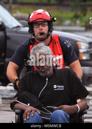Älterer Flieger John J. Kosequat, ein pararescueman mit der 103 Rescue Squadron der 106 Rettung Flügel an der New York Air National Guard zugeordnet, schiebt einen älteren Mann in Richtung HH-60 Hawk Hubschrauber in Houston Bereich ebnen, 30. August 2017. Der Mann war sicher zu einem lokalen Krankenhaus transportiert. Daniel H. Farrell/U.S. Air National Guard/UPI Stockfoto