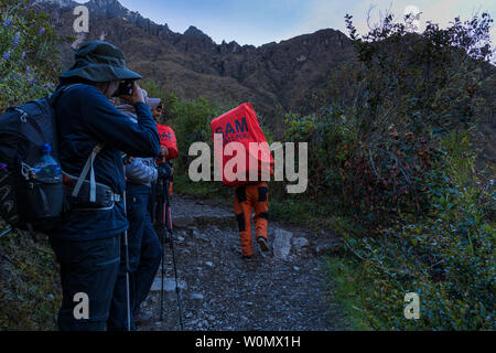 Träger mit ihren großen schweren Rucksäcken auf dem Inka Trail, Tag 2, Huayllabamba, über Ara de Huarmihuanusca, Toten womans, Pacay Mayo Alto, Pro Stockfoto