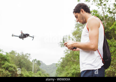 Seitenansicht eines Jungen lernen eine Drohne im Außenbereich zu fliegen Stockfoto