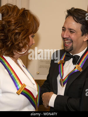 Reba McEntire, Links, und Lin-Manuel Miranda, rechts, zwei der Empfänger der 41st jährlichen Kennedy Center Honors converse vor für ein Gruppenfoto posieren nach einem Abendessen, United States Stellvertretender Außenminister John J. Sullivan zu ihren Ehren bewirtet an das US-Außenministerium in Washington, D.C. am Samstag, 1. Dezember 2018. Die Preisträger 2018 sind: Sängerin und Schauspielerin Cher; Komponist und Pianist Philip Glass; Country Musik entertainer Reba McEntire, und Jazz Saxophonist und Komponist Wayne Shorter. In diesem Jahr, die mitschöpfer von Hamilton, - Schriftsteller und Schauspieler Lin-Manuel Miranda; Direktor Stockfoto