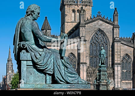 Die Statue des David Hume von Bildhauer Alexander Stoddart auf der Royal Mile in Edinburgh bei St Giles Kathedrale im Hintergrund. Stockfoto