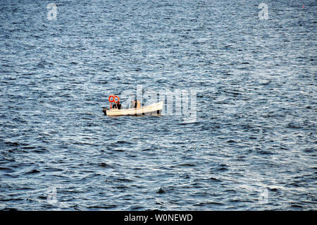 Großes Meer, kleinen Boot. Zwei Küstenfischer prüfen ihre Krabben und Hummer Töpfe in der Nähe von pittenweem an der Ostküste von Schottland. Stockfoto