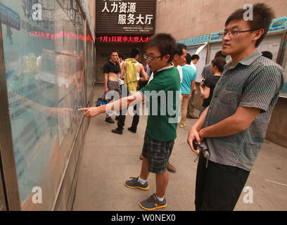 Chinesische Männer und Hochschulabsolventen die neuesten Beschäftigung Auflistungen auf einem öffentlichen Job Board außerhalb ein Arbeitsamt in Xi'an, die Hauptstadt der Provinz Shaanxi, am 1. Juli 2012. Die Arbeitslosenquote hat sich in den letzten Monaten deutlich gestiegen und die Aussichten in diesem Jahr voraussichtlich höher sein als im letzten Jahr. Über dem Land, die Arbeitslosigkeit so düster, wie Millionen von Hochschulabsolventen beschrieben ist, jagt nach Jobs zu suchen. Mehr als 25 Prozent der diesjährigen Absolventen haben es versäumt, Jobs zu finden, entsprechend einem neuen Report. UPI/Stephen Rasierer Stockfoto