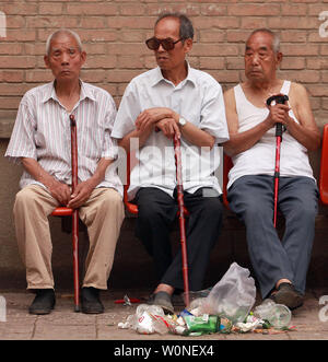 Ältere chinesische Männer sitzen im Schatten, wie Sie das Kommen sehen - und - Bewegungen in ihrer Nachbarschaft in Xi'an, die Hauptstadt der Provinz Shaanxi, am 1. Juli 2012. Chinas Bevölkerung ist vergreisung schneller und schneller, Bedenken über die zunehmende wirtschaftliche und sozialen Druck in das bevölkerungsreichste Land der Welt. Im November 2010 gab es in China 178 Millionen Menschen über 60 Jahre alt, von denen 119 Mio. über 65. Für über 22 Prozent der Gesamtbevölkerung, und ist China das einzige Land auf der Erde mit mehr als 100 Millionen ältere Menschen. UPI/Stephen Rasierer Stockfoto