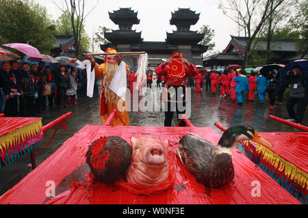 Durchführen einer traditionellen chinesischen Qing Ming (Grab Fegen) Zeremonie zu Ehren Cai Lun in seinem Grab Tempel, mit Tänzen, bei denen ein leben Hühner, ein Schwein Kopf und eine Ente, in einer kleinen Stadt in der chinesischen Provinz Shaanxi, zentral am 6. April 2015. Cai Lun war ein chinesischer Eunuch und politischen Beamten zu Kaiser Er und ist historisch als Erfinder des Papiers und die papermakiing Prozess betrachtet, in den Formen erkennbar in den modernen Zeiten wie Papier. Foto von Stephen Rasierer/UPI Stockfoto