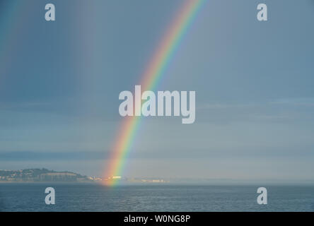 Dramatische rainbow Formulare Über eine Kreuzfahrt Schiff auf dem Meer Stockfoto