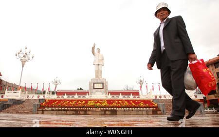 Chinesische Touristen fotografieren vor einer der wenigen verbliebenen öffentlichen Satzung der späten Steuermann Mao Zedong in ein Quadrat in Lijiang, nördliche Yunnan Provinz, am 29. September 2012. Während der Kulturrevolution unter der Roten Garde, Maos bereits verherrlicht Bild in einem Personenkult, die jeden Aspekt der chinesischen Lebens beeinflusst offenbarte, und weiterhin besteht zu über dem Land. UPI/Stephen Rasierer Stockfoto