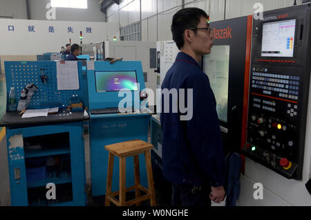 Eine Chinesische Techniker überwacht die präzises Bohren der Luftfahrt Gasturbine Komponenten durch Software-gesteuerte Maschinen Hanyu der Produktionsstätte in Zigong, Provinz Sichuan, am 16. November 2017. Hanyu produziert Schlüsselkomponenten für Luftfahrt und Gasturbinenschaufeln, von denen einige militärische sind ab und sind in die Vereinigten Staaten exportiert. Foto von Stephen Rasierer/UPI Stockfoto