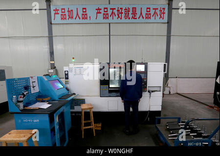 Eine Chinesische Techniker überwacht die präzises Bohren der Luftfahrt Gasturbine Komponenten durch Software-gesteuerte Maschinen Hanyu der Produktionsstätte in Zigong, Provinz Sichuan, am 16. November 2017. Hanyu produziert Schlüsselkomponenten für Luftfahrt und Gasturbinenschaufeln, von denen einige militärische sind ab und sind in die Vereinigten Staaten exportiert. Foto von Stephen Rasierer/UPI Stockfoto